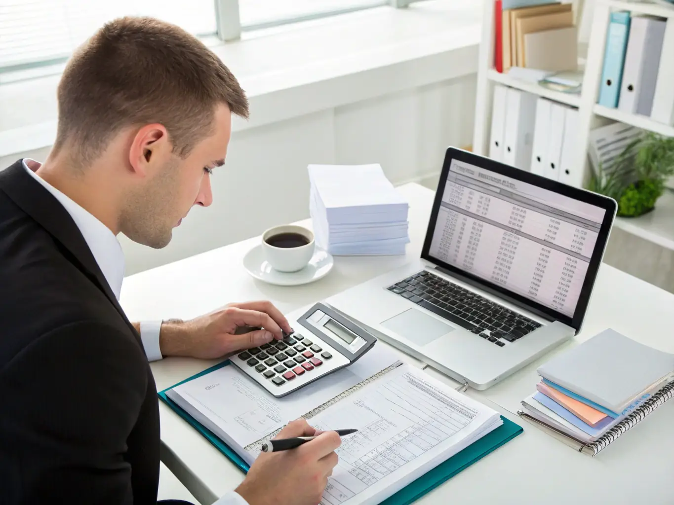 An image of a professional accountant working on financial statements with spreadsheets and a computer, representing accounting and bookkeeping services.